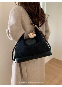 Detail of a retro black tote bag with plush texture, bear charm and printed silk scarf