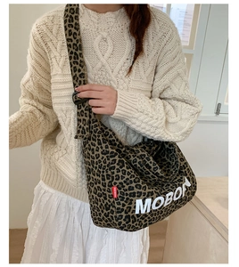 Detailed view of leopard print canvas tote bag with Mobon lettering and adjustable strap
