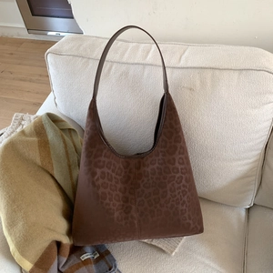 Détail du sac hobo à imprimé léopard avec poignée en cuir et texture daim doux