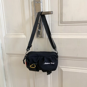 Detail der schwarzen Nylon-Umhängetasche mit Mobern Bag-Logo und gelbem Kordelzug