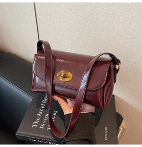 Détail du sac à bandoulière bordeaux brillant avec fermoir rotatif à carreaux dorés