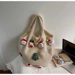 Detail of knit shoulder bag with 3D Christmas patches and vertical woven texture