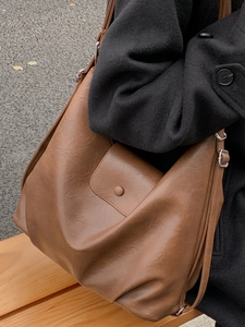 Retro large capacity brown leather tote bag for women showing outdoor shoulder carry style
