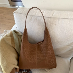 Détail du sac hobo à imprimé léopard marron chaud sur un canapé en tissu blanc