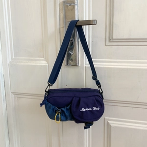 Detailansicht der lila Nylon-Umhängetasche mit Moborn Bag Bestickung und verstellbarem Gurt