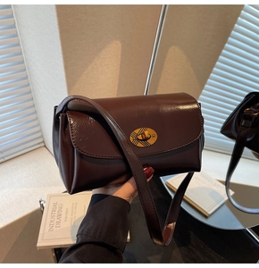Détail d'un sac à main en cuir marron avec fermoir doré vintage et finition brillante