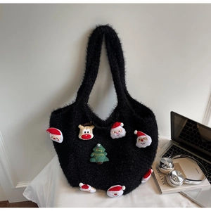 Close-up of black plush handbag with festive Christmas Santa and reindeer patches
