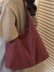 Chic burgundy leopard-embossed hobo tote bag for women shown in a lifestyle street style