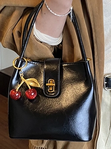 Retro black glossy bucket bag for women with gold clasp and a cute cherry charm