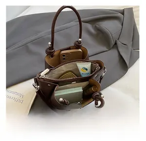 Macro shot of the brown leather bucket bag interior showing dual compartments and storage