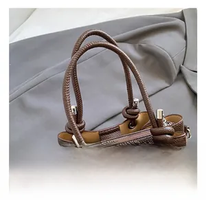 Detailed close-up of brown litchi grain leather bag with sturdy knots and metal hardware