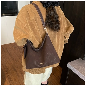 Deep brown matte hobo bag with contrast stitching and golden logo on shoulder