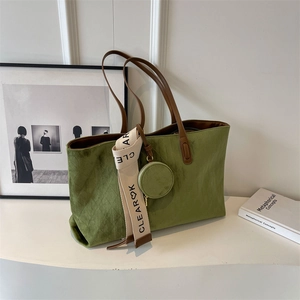 Detail of green suede tote bag with quilted diamond pattern and a small round coin purse