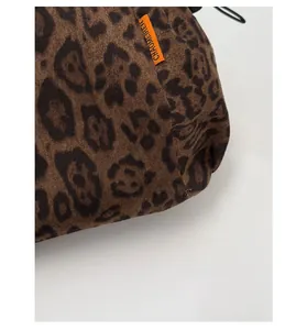 Macro shot of leopard print canvas backpack fabric with orange woven brand label