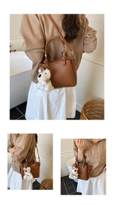 Brown litchi grain leather bucket bag with knotted handle detail and puppy charm
