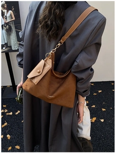 Detail of a brown frosted leather hobo bag with a matching mini envelope pouch attachment
