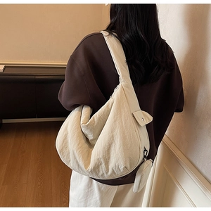 Vue détaillée arrière d'un grand sac bandoulière beige en forme de lune avec pochette