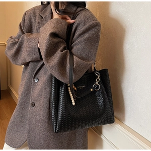 Détail de la texture en cuir tressé noir avec logo texte Fashion & BaG EST.1985