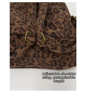 Detail of adjustable shoulder straps with vintage copper buckles on leopard print backpack