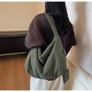 Détail du grand sac hobo vert olive avec large bandoulière et pochette ronde assortie