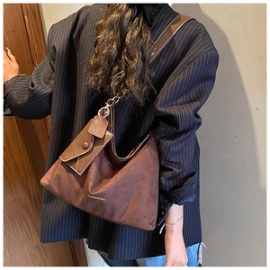 Brown frosted leather tote bag with brand logo and mini envelope charm on shoulder