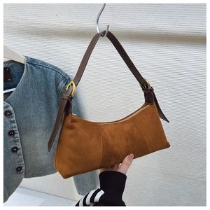 Detailed macro view of the brown suede underarm bag with gold metal buckle and zipper