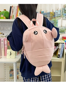 Detail of creative pink shrimp backpack with 3D segments and straps on a person