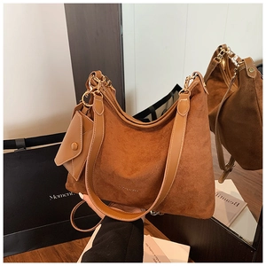 Macro view of caramel brown suede hobo bag with gold hardware and mini coin purse detail
