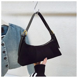 Detail of black suede hobo bag featuring adjustable golden buckle and zipper closure