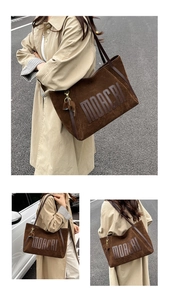 Detailed macro view of the MOACRI embossed lettering on dark brown matte tote bag