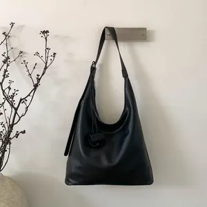 Détail du sac hobo en cuir noir avec le marquage Muting and Bags sur la base du sac