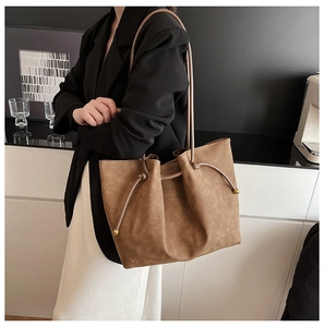 Detail of vintage brown tote bag with metal ball drawstring and long straps