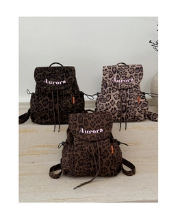Detailed close-up of leopard print canvas backpacks with drawstring and Aurora embroidery