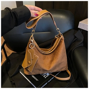 Detail of vintage brown frosted suede hobo bag with dual straps and small coin pouch charm