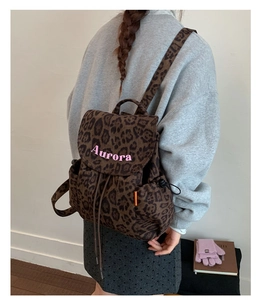Close-up of leopard print canvas backpack with Aurora pink embroidery and side pocket