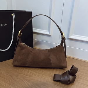 Brown suede baguette bag with gold hardware and extra shoulder strap in a stylish scene