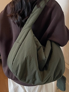Grand sac bandoulière vert olive en nylon plissé porté par un mannequin femme