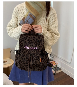 Detail of retro leopard print backpack featuring pink Aurora embroidery and drawstring