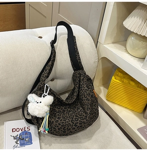 Gros plan du sac bandoulière à motif léopard avec grande capacité et breloque peluche chien