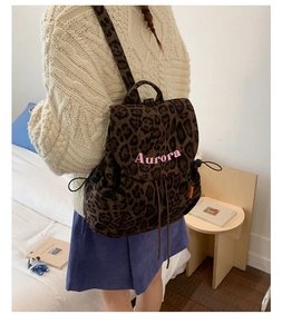 Detail showing the pink Aurora embroidery and trendy leopard print on canvas backpack