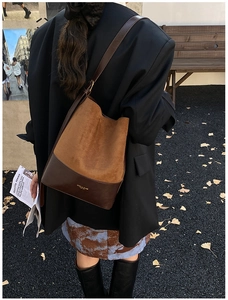 Chic brown suede bucket bag shown in a stylish autumn outdoor street fashion scene