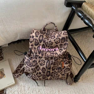 Detail view of leopard print canvas backpack with pink Aurora embroidery and drawstring closure