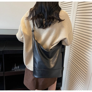 Detail der minimalistischen schwarzen matten Leder-Eimertasche mit Ziernaht und Schultergurt