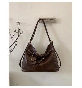 Detail of dark brown vintage faux leather hobo bag with mini coin purse and white stitching