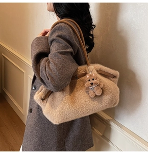 Dettaglio della borsa tote in ecopelliccia beige con ciondolo a forma di cane e manici