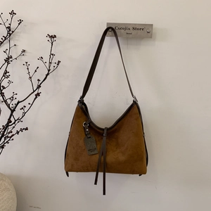Détail du grand sac cabas en daim marron foncé avec finitions en cuir lisse