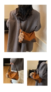 Detail view of suede leopard print shoulder bag with leather strap and bear charm accessory