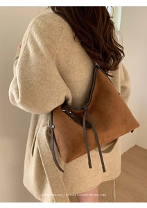 Détail du sac cabas en daim marron avec bordures en cuir et lanière à franges