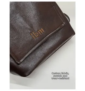 Close-up detail of dark brown leather fabric with textured finish and ibm logo