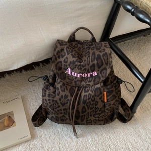 Close-up of leopard print canvas backpack with drawstring closure and Aurora embroidery